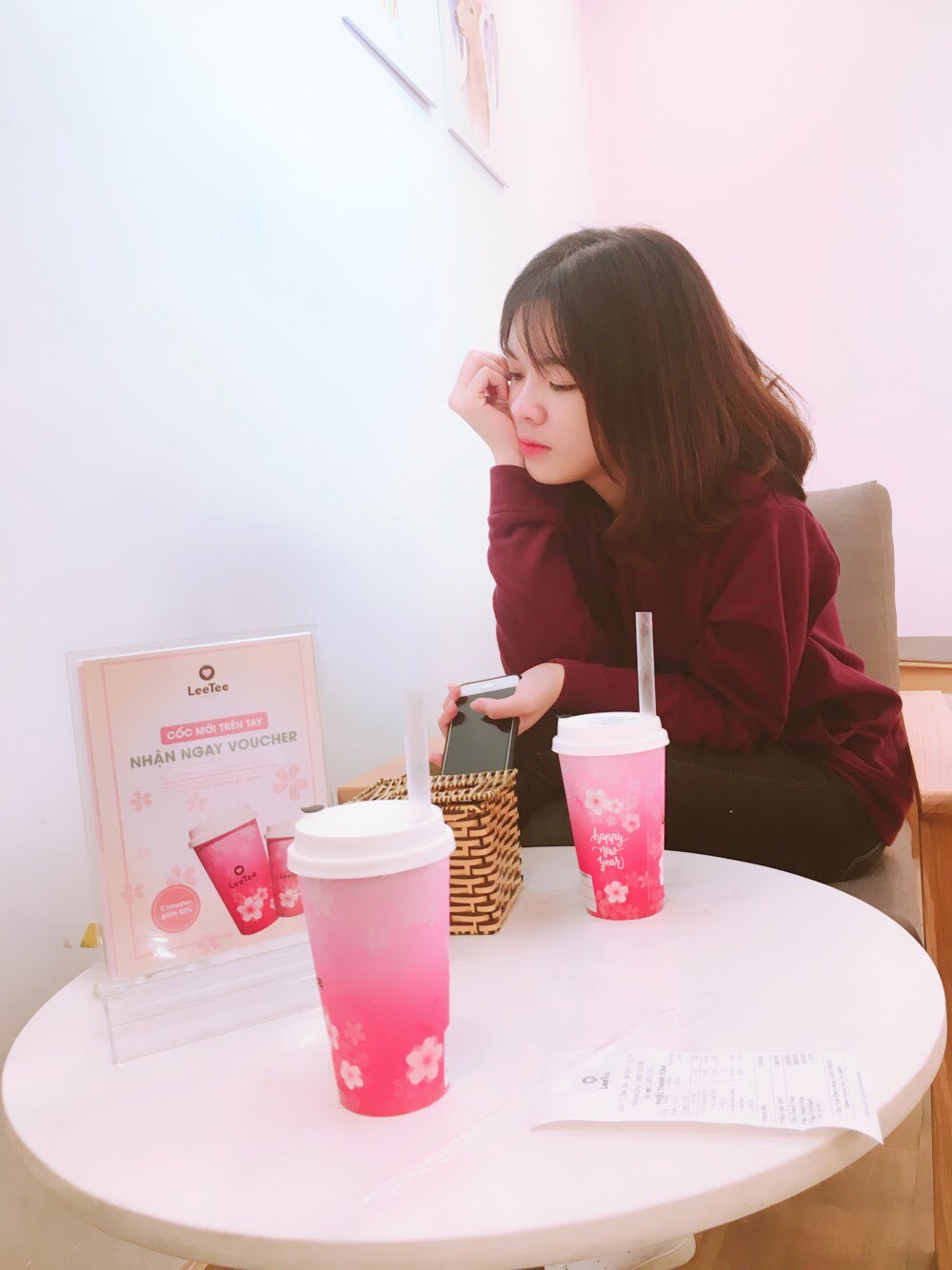 Cô gái ngồi bàn trà sữa
